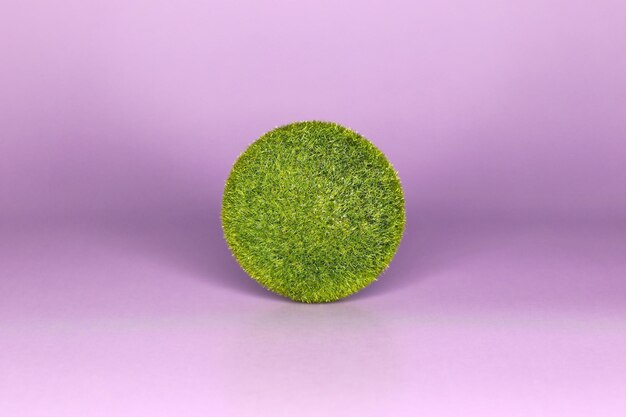 A ball of green grass on a purple background very peri