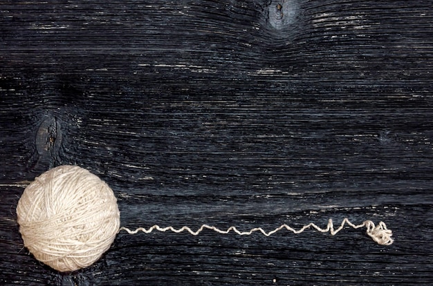Foto un gomitolo di fili per maglieria su uno sfondo di legno nero