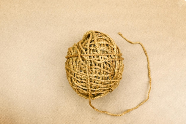 A ball of yarn is on a beige background.