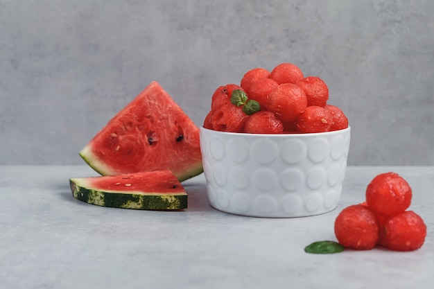 Ballen van watermeloen. Fruitsalade met watermeloenballen en munt in een witte plaat.