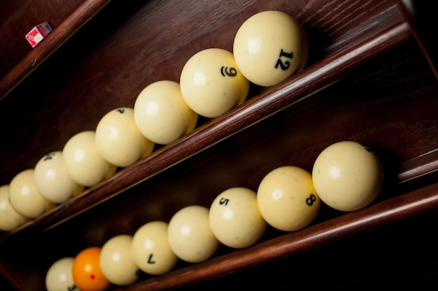 Ballen voor poolbiljart op de plank, biljartballen voor Amerikaans biljart, ballen voor Russisch biljart, gekleurde of witte ballen voor biljart op een houten achtergrond. Close-up foto. Zachte focus.