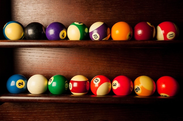 Ballen voor poolbiljart op de plank, gekleurde of witte ballen voor biljart op een houten ondergrond.