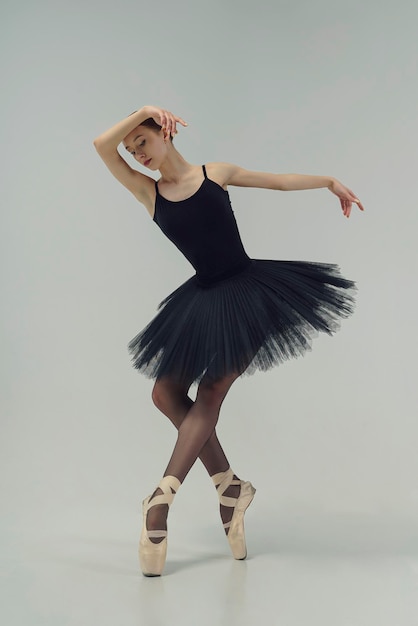 Ballerina in a black tutu shows elements of ballet dance in motion