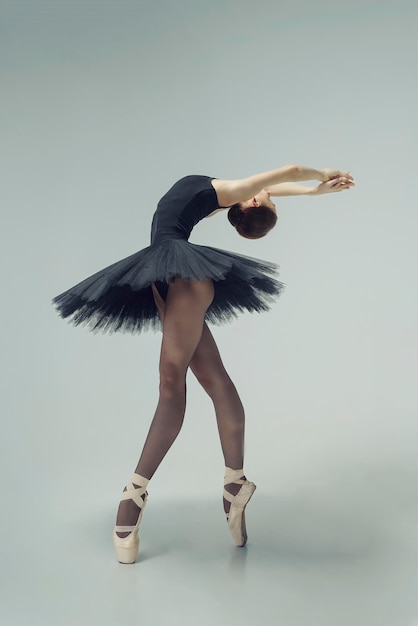 Ballerina in a black tutu shows elements of ballet dance in motion