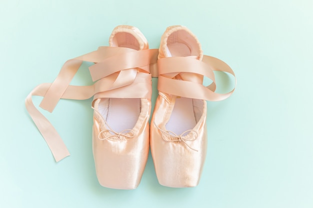 Ballerina classical pointe shoes for dance training isolated on blue background