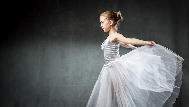 Ballerina. bambina sveglia che posa e che balla nello studio. la ragazza studia balletto.