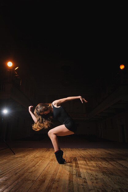 Ballerina dancer dancing on the toes indoor with balck background