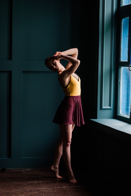 Foto ballerina in una stanza buia in un body