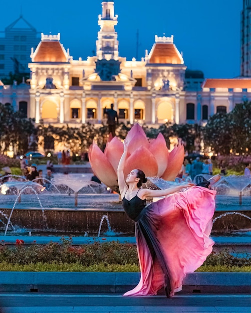 Ballerina doing splits in the air on the square in city hall of ho chi minh city in vietnam