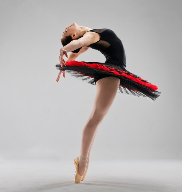 Балерина в полный рост стоит в пуантах с пачкой