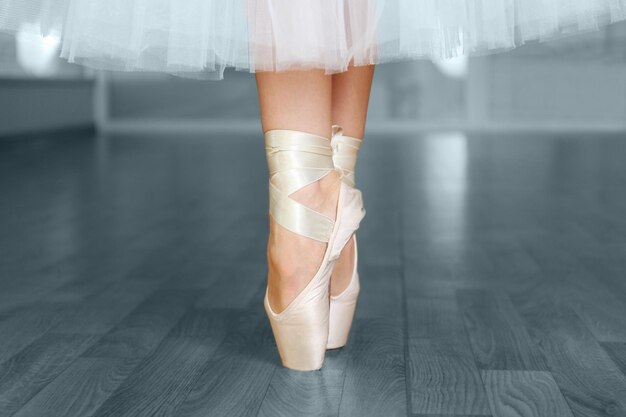 Ballerina legs in pointes in dancing hall