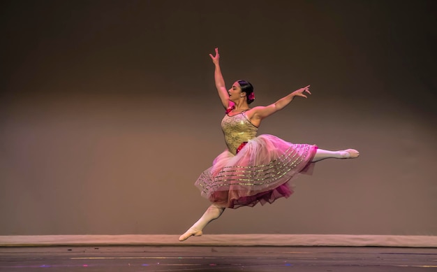 Foto una ballerina in abito rosa esegue una danza.