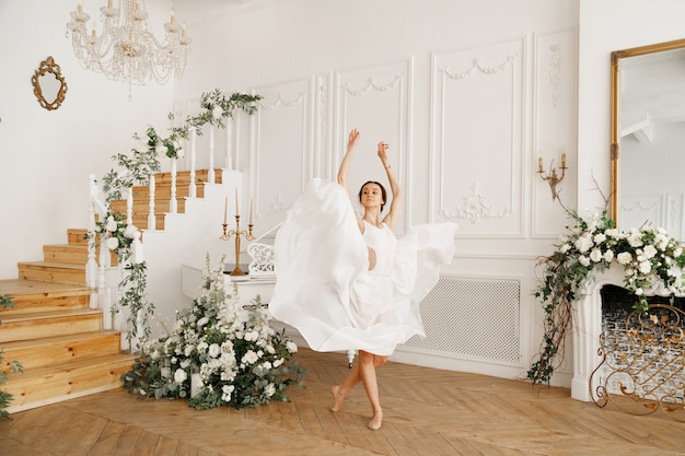 Ballerina in a white dress in a classic vintage hall