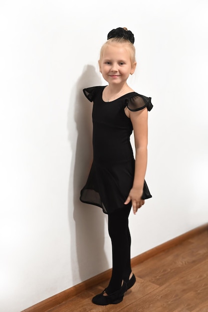 Foto ballet babydanseres in positie in zwart uniform