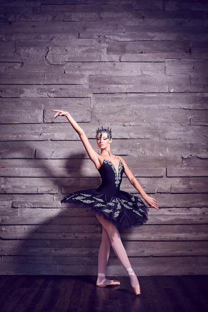 Ballet dancer dancing against wall