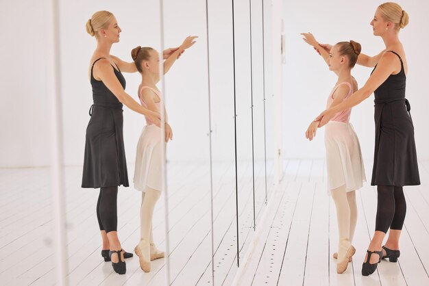 사진 발레 교육 교사와 소녀 댄서는 전문 예술 스튜디오 홀에서 강사에게 거울을 보고 배우며 공연 아카데미 수업에서 균형을 유지하는 무용 코치 훈련 발레리나 학생