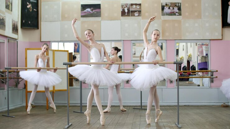 Photo in the ballet hall girls in white ballet tutus packs are engaged at ballet rehearse croise forward