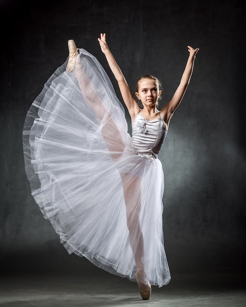 Ballet. Image of a flexible cute ballerina dancing in the studio. Beautiful young dancer. A ballerina is posing.