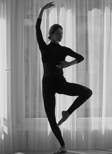 Balletdanser jonge ballerina thuistraining fitness sportvrouw die zich uitstrekt voordat ze vrouw traint