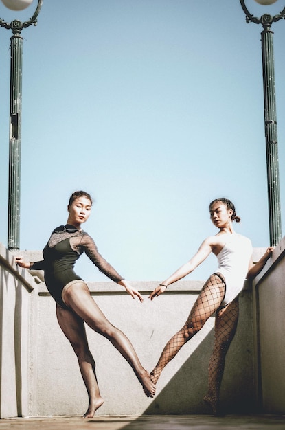 Foto balletdansers in badpak staan tegen een heldere hemel