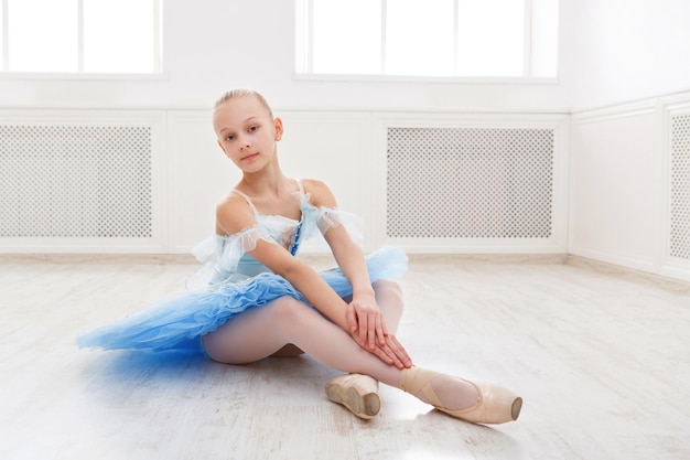 Balletstudent die in balletkostuum uitoefent, die op haar tenen staat. Jonge tienerballerina die klassieke danspas in studio beoefent vóór de uitvoering