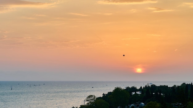 Ballon drijvend in de lucht in de verte op de achtergrond zonsondergang over de zee