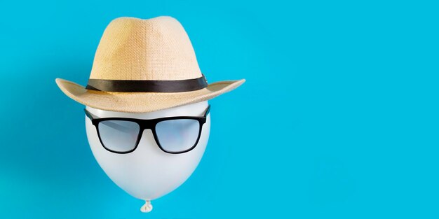 Foto ballon toeristische close-up het beeld van een mannelijke reiziger in een hoed en zonnebril concept toeristische bestemming