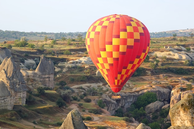 Ballon vliegt in bergachtig gebied in Cappadocië