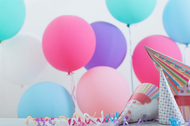 Ballons and birthday hats on festive background