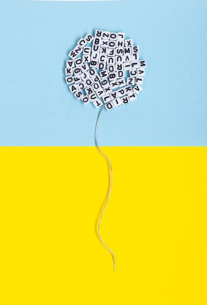 Balloon made of letters on a yellow and blue background