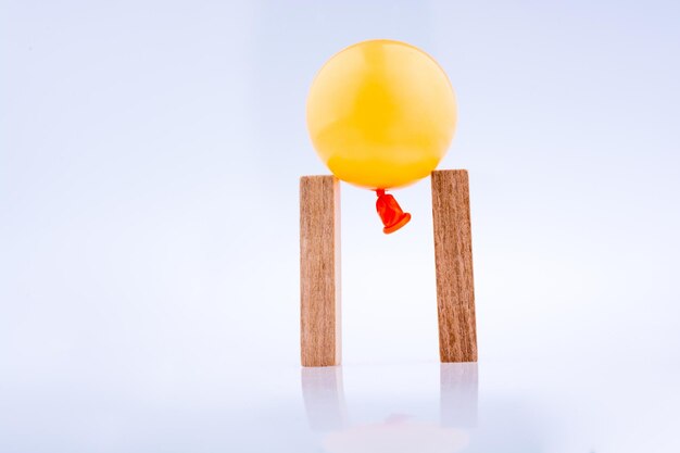 Balloon and wooden domino on white background
