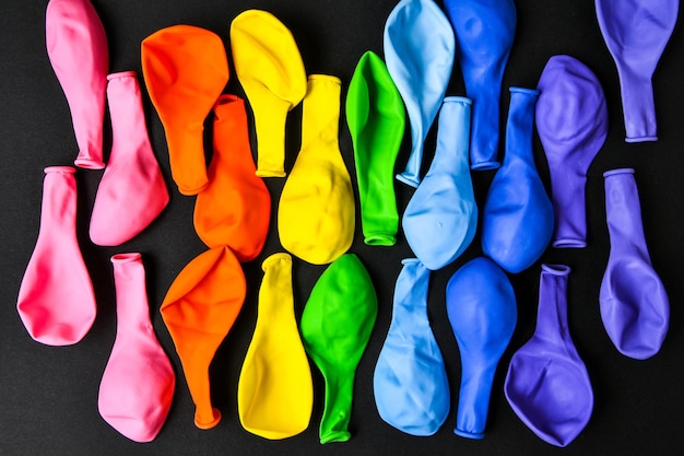 Foto palloncini colori arcobaleno su uno sfondo nero come una bandiera di un arcobaleno di orgoglio lgbt diversi