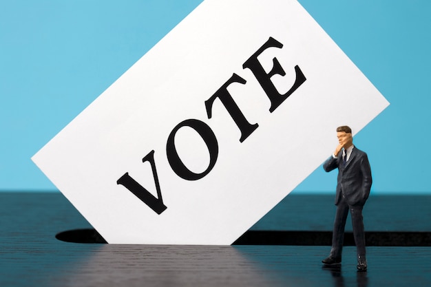 Ballot box with miniature man voter