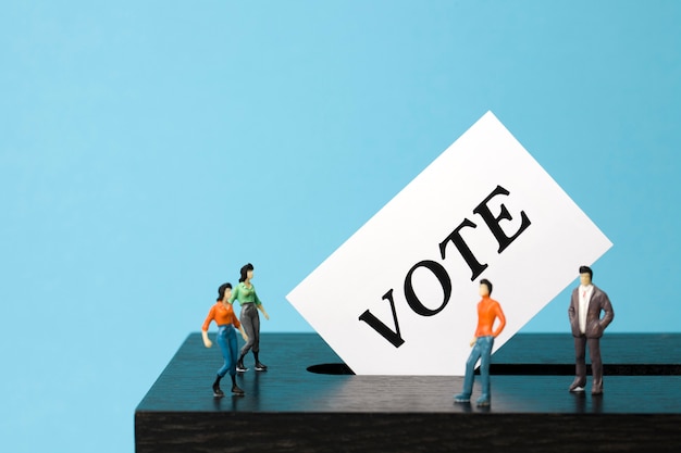 Photo ballot box with miniature people voters