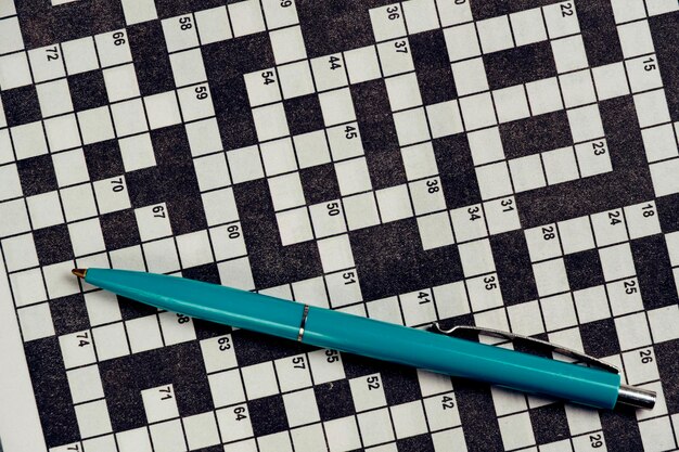 Ballpoint pen is lying on piece with crossword puzzleHobby concept and mental recreation