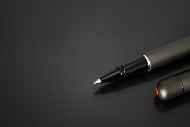 Photo ballpoint pen and pens cap on dark background with luxury style.