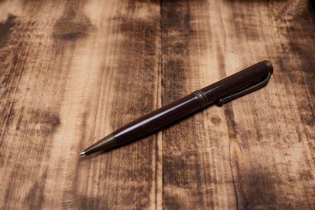 Foto penna a sfera di legno su sfondo di legno