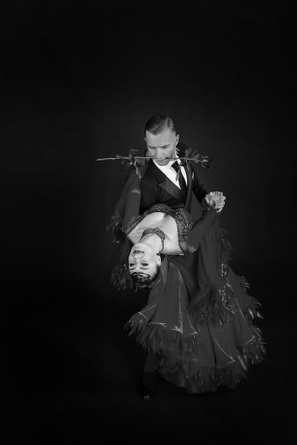 Ballroom dance couple dance pose isolated on black background\
sensual professional dancers