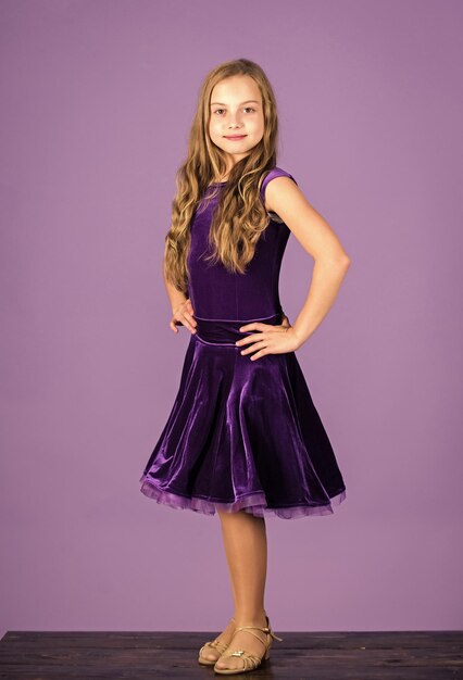 Foto ballroom danskleding mode concept kind danser tevreden met concert outfit meisje schattig kind dragen fluweel violet jurk kleding voor ballroom dans kids mode kind modieuze jurk ziet er schattig uit