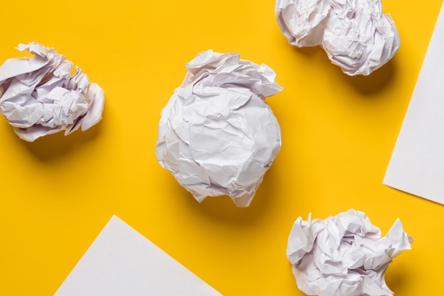 Balls of crumpled paper and white sheets of paper in the form
of triangles with space for text