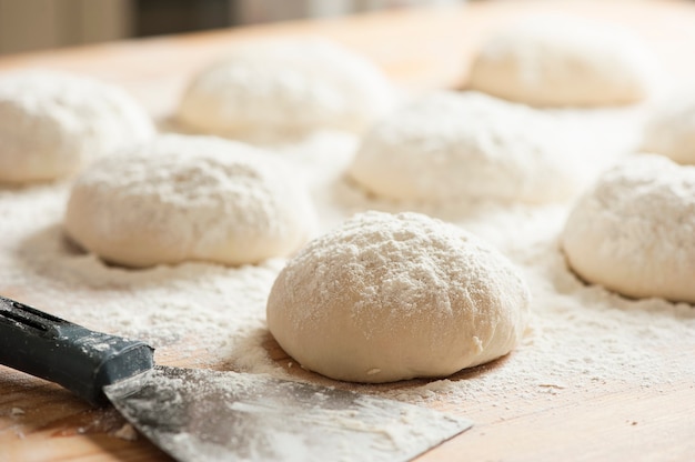 Balls of dough covered with wheat flour ready for baking