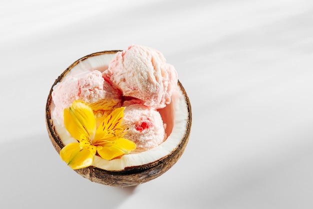 Balls of ice cream decoration flowers in halves of coconut. Summer tropical concept.