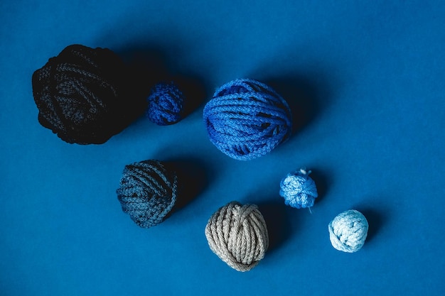 Balls of threads of dark blue light blue gray colors on a blue background