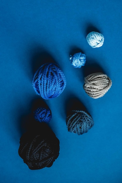 Balls of threads of dark blue light blue gray colors on a blue background