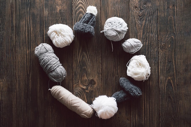 Foto gomiti di lana lavorati a maglia cappellino e ferri da maglia in legno su sfondo di legno hobby craft concetto di lavoro a maglia