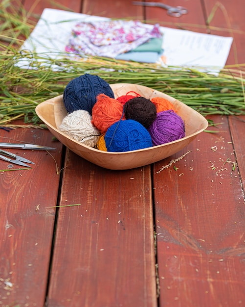 Balls of woolen yarn for knitting on a wooden table Knitting in nature Needlework in the garden