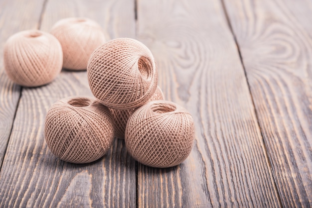 Balls of yarn thread for knitting on a wooden background.