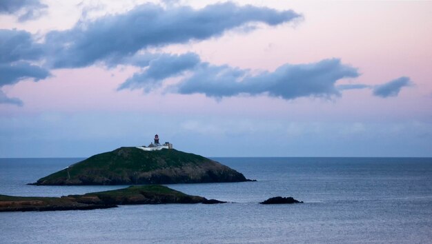 Foto isola di ballycotton e faro in cork ireland, compreso il faro circondato dal mare