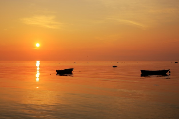 Baltic sea early morning golden sunrise over the sea Fishing boats on the sea against the background of sunrise and sunlight Kurzeme Latvia