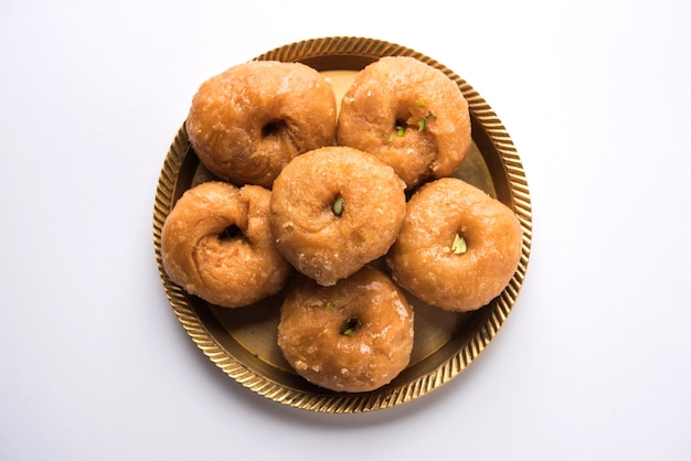 Photo balushahi sweet food served in a white or golden plate over moody background